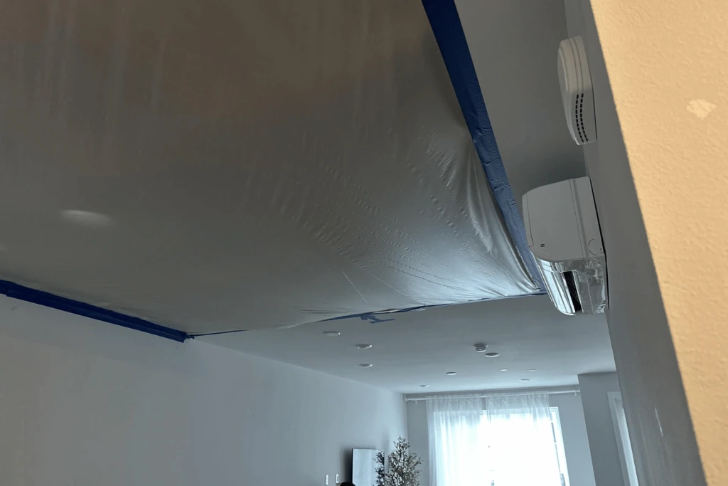 Ceiling protected with plastic containment sheeting.