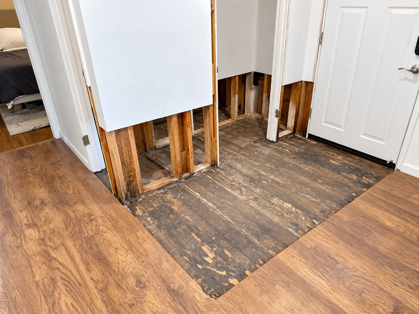 Hallway and closet walls flood-cut to the studs with wet flooring removed down to the subfloor during water damage restoration
